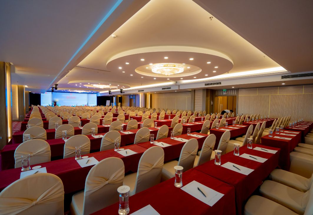 Không gian hội trường trang trọng với sân khấu chính hiển thị chủ đề hội nghị sơ kết 6 tháng đầu năm của doanh nghiệp.